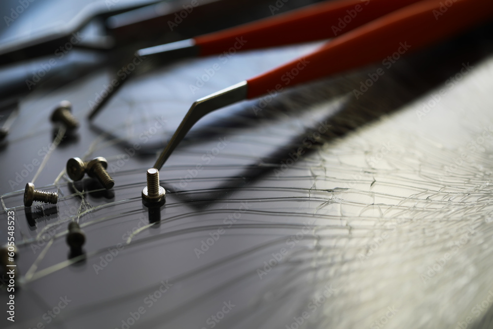 Smartphone with a broken screen and repair tools on the dark background. Close-up. Smartphone with a broken screen and repair tools on the dark background. Close-up.