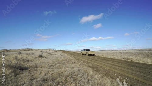 Ranch truck slips and slides in gumbo mud as it climbs hill on ranch road