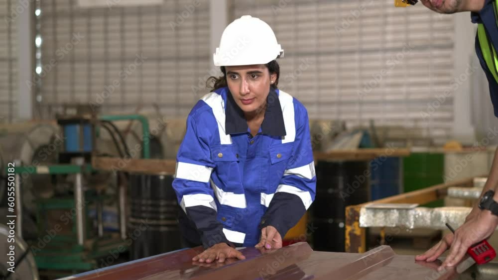 Young inspector female and foreman checking quality of metal sheet in factory Young inspector female and foreman checking quality of metal sheet in factory
