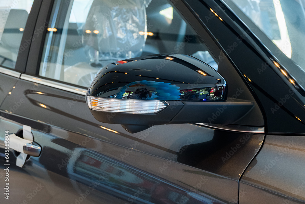 Fototapeta premium Close up Side mirror on car of black in modern showroom waiting for sales.