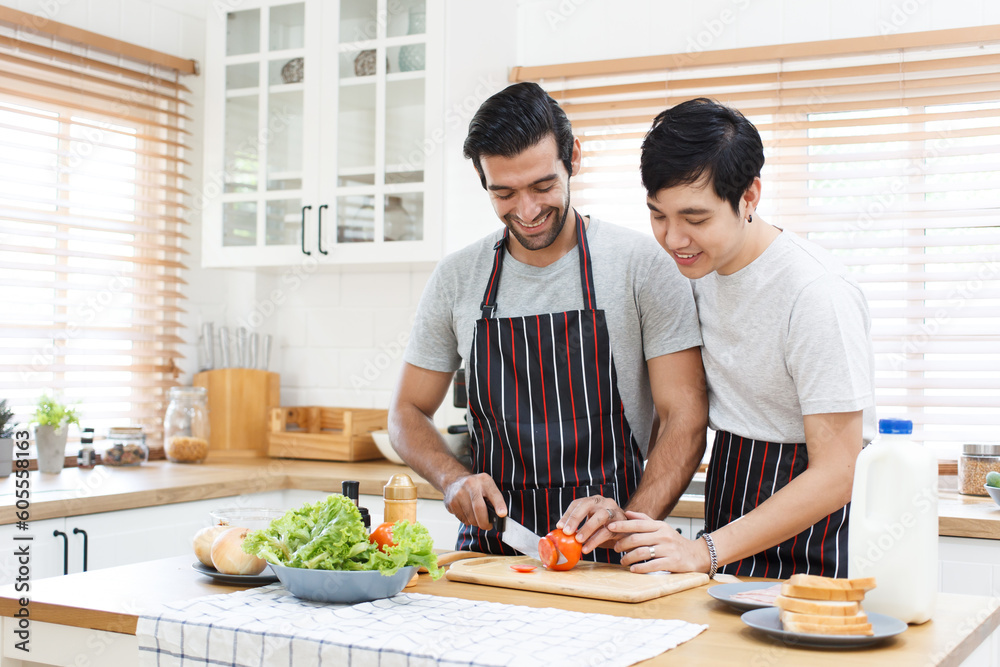 Happy cheerful LGBTQ+ gay romantic couple preparing and making their breakfast together in the kitchen. Happy cheerful LGBTQ+ gay romantic couple preparing and making their breakfast together in the kitchen.