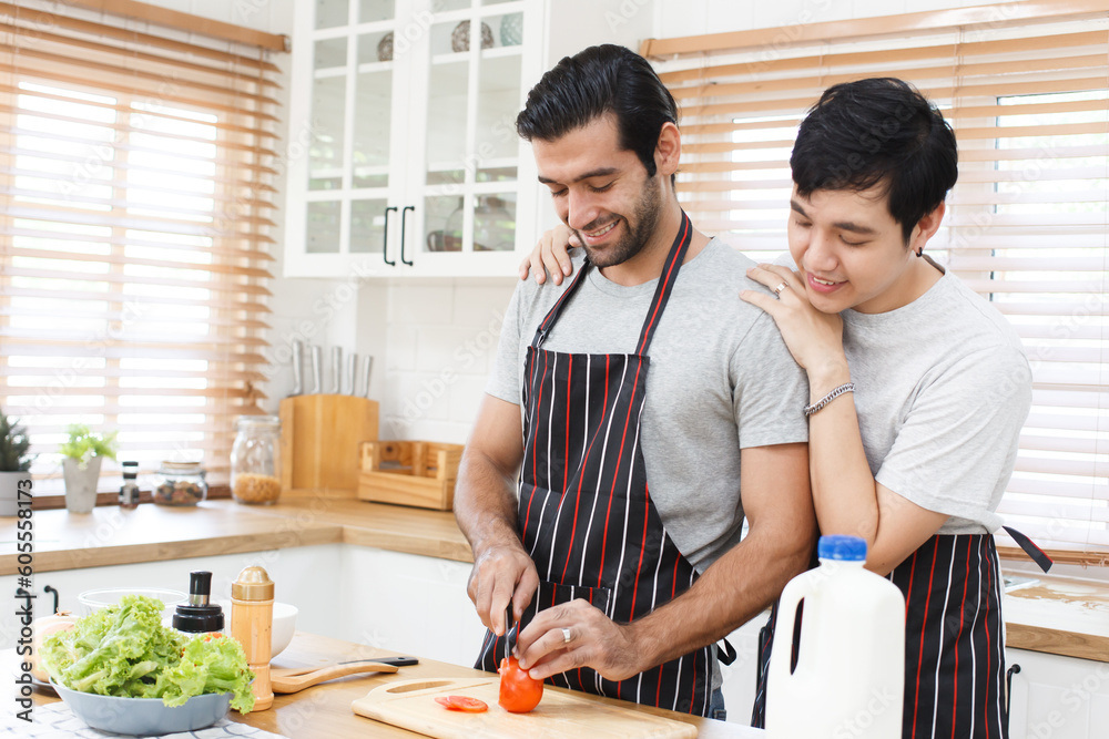 Happy cheerful LGBTQ+ gay romantic couple preparing and making their breakfast together in the kitchen. Happy cheerful LGBTQ+ gay romantic couple preparing and making their breakfast together in the kitchen.