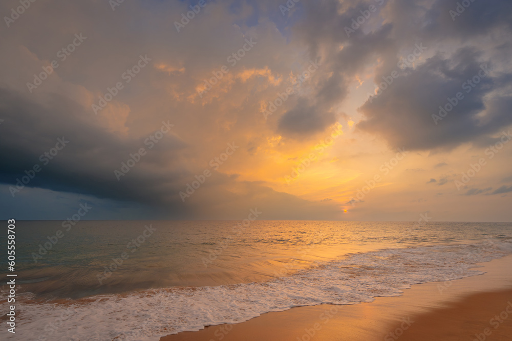 Beautiful evening scenery with sandy ocean beach under a beautiful sunset sky with clouds on Sri Lanka island.