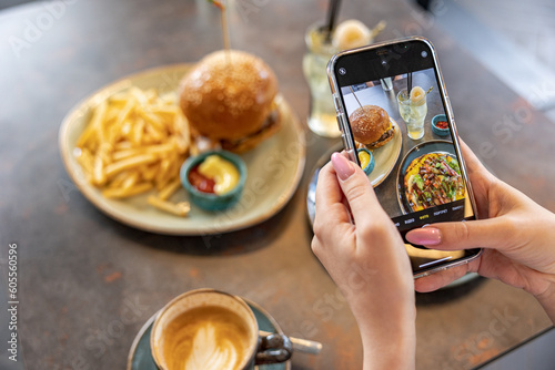 Top view of young woman taking aesthetic photo of food using smartphone in home studio photo