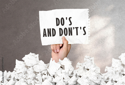 Hand holds a piece of paper with text dos and donts on a gray wall background photo