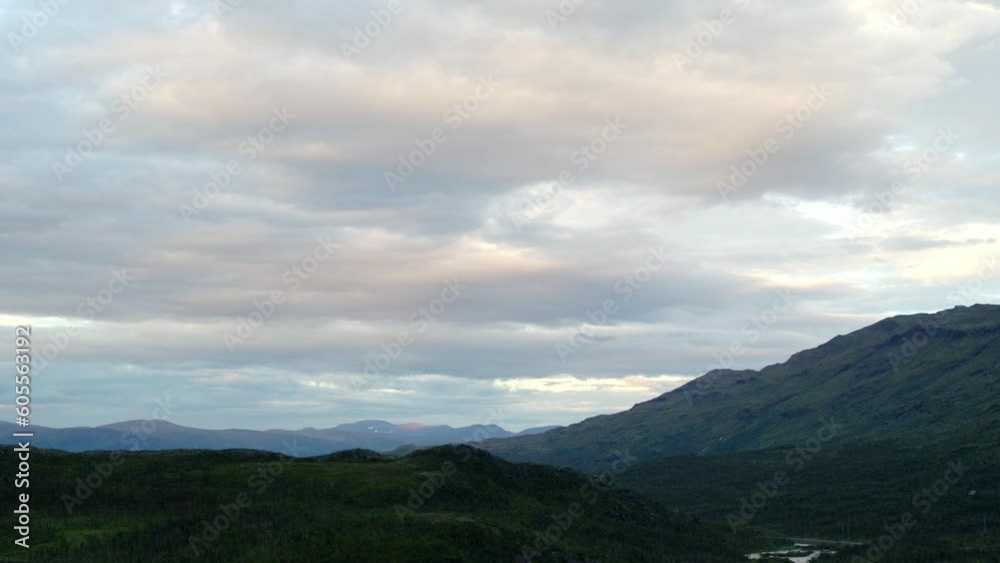 Green mountains and cloudy sky at dusk in northern Sweden, aerial pan Green mountains and cloudy sky at dusk in northern Sweden, aerial pan
