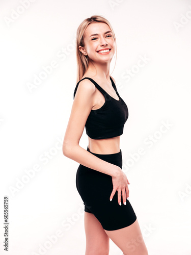 Young beautiful smiling blond female in summer black cycling shorts costume clothes. Sexy carefree woman posing on white in studio. Positive model having fun. Cheerful and happy