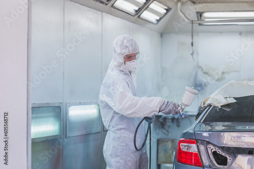 Worker man using spray gun and airbrush and painting a car, Mechanic painting car in chamber, Garage painting car service repair and maintenance