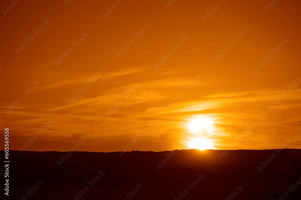 Dramatic Sky with a Black Mountain Silhouette in foreground, Play of Light and Shadow. sun set above horizon line.