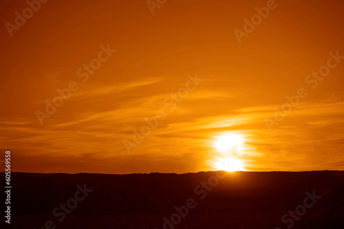 Fototapeta Naklejka Na Ścianę i Meble -  Dramatic Sky with a Black Mountain Silhouette in foreground, Play of Light and Shadow. sun set above horizon line.