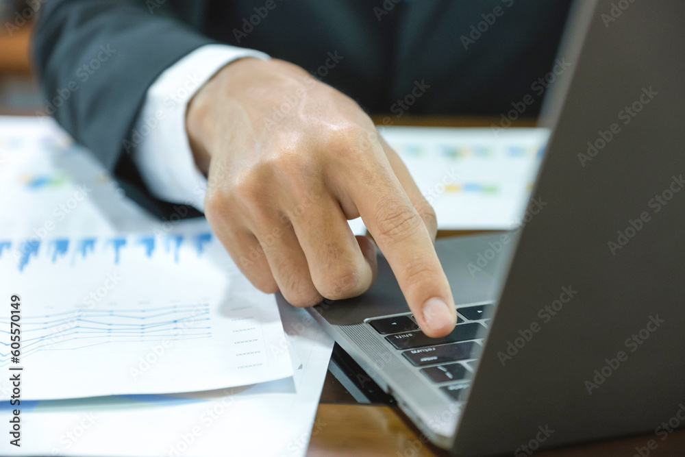 Businessman hand use laptop and analysis the graph at the home office for setting challenging business goals and plan to achieve the new target Businessman hand use laptop and analysis the graph at the home office for setting challenging business goals and plan to achieve the new target