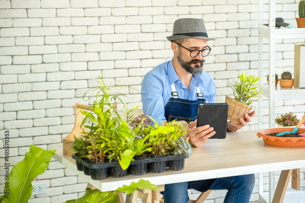 Hipster elderly men learn to take care of plants online with tablets and show trees, a hobby of urban home gardening after sustainable retirement Hipster elderly men learn to take care of plants online with tablets and show trees, a hobby of urban home gardening after sustainable retirement