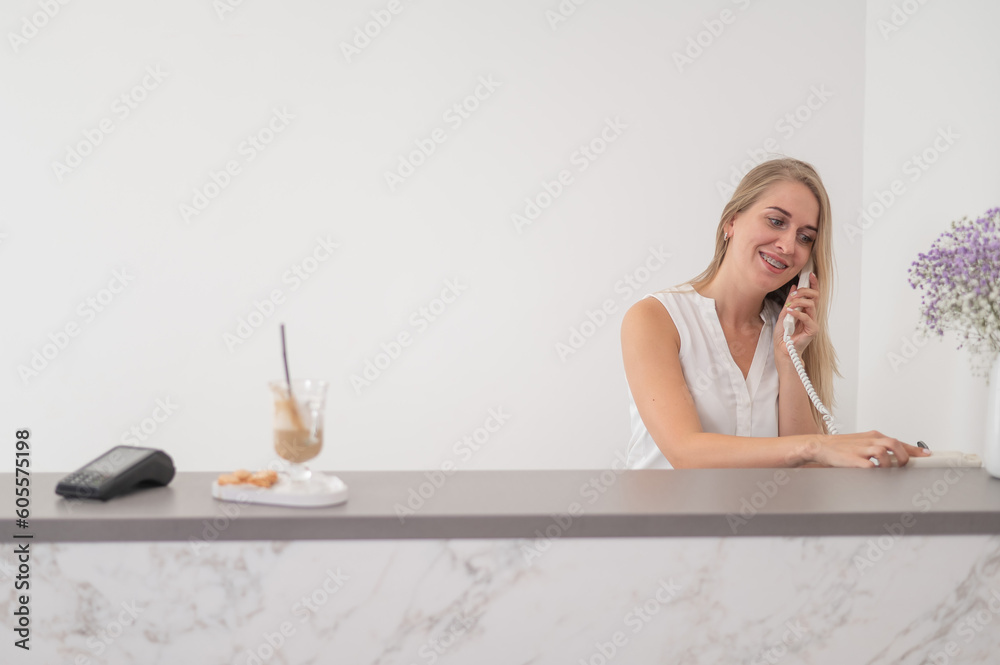 Receptionist in a beauty salon talking to a client on the phone. Receptionist in a beauty salon talking to a client on the phone.