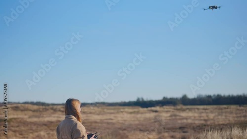 a girl flying a drone in a field