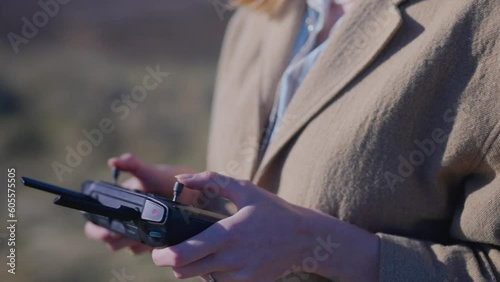 pretty girl flying a drone in a field