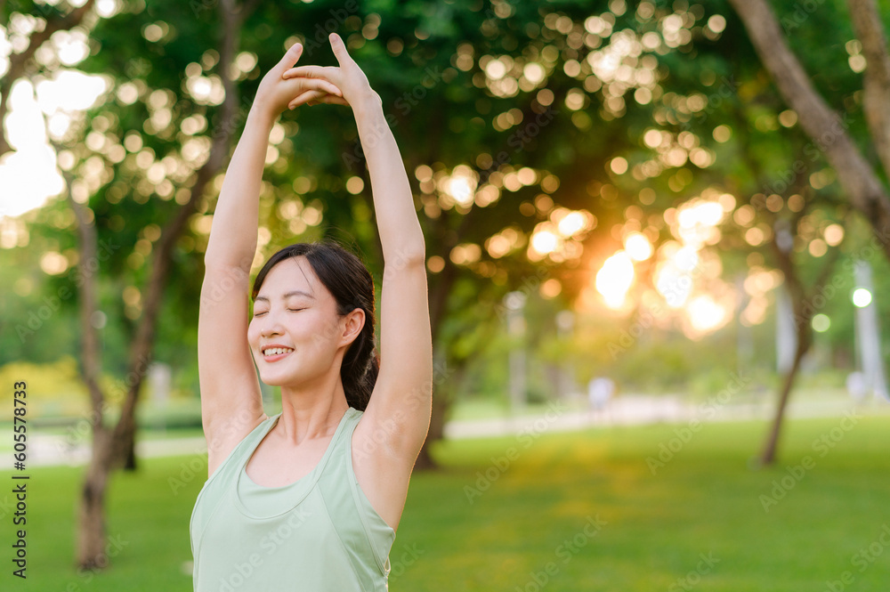 Female jogger. Fit young Asian woman with green sportswear stretching muscle in park before running and enjoying a healthy outdoor. Fitness runner girl in public park. Wellness being concept Female jogger. Fit young Asian woman with green sportswear stretching muscle in park before running and enjoying a healthy outdoor. Fitness runner girl in public park. Wellness being concept