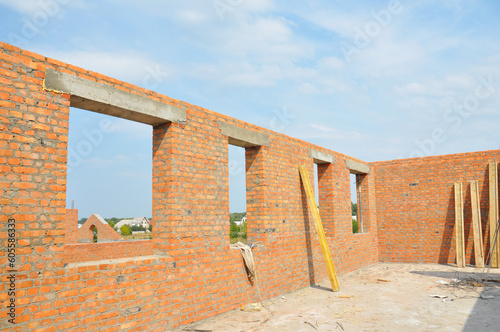 Photography Unfinished brick house construction with windows, concrete lintels and no roof