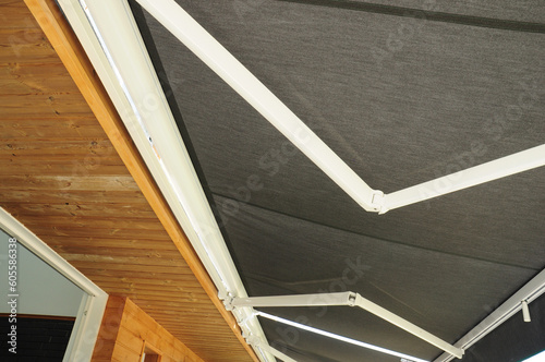 Close up on holders of automatic sliding canopy retractable roof system, patio awning for sunshade of a house.