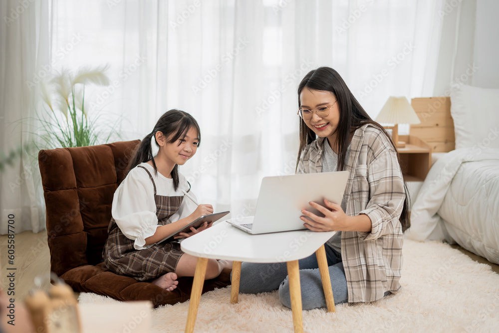 Asian Mother Teaching Children Online Learning on Laptop in white room of Home Happy Smile Asian Mother Teaching Children Online Learning on Laptop in white room of Home Happy Smile