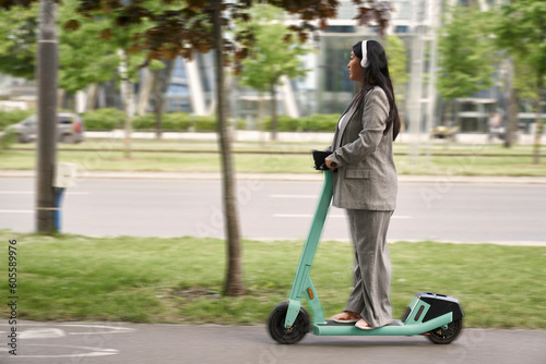 Photography Chinese business woman riding on push scooter and listening to music