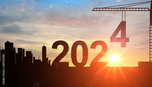 2024. New Year 2024. Construction crane sets numbers for New Year 2024, Silhouette of team works as a to prepare to welcome new year 2024 silhouette on sunrise background photo