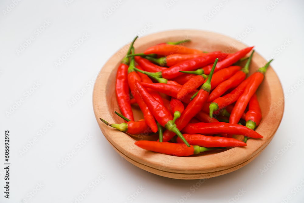 Top view  red chilies on a wooden plate on a white background