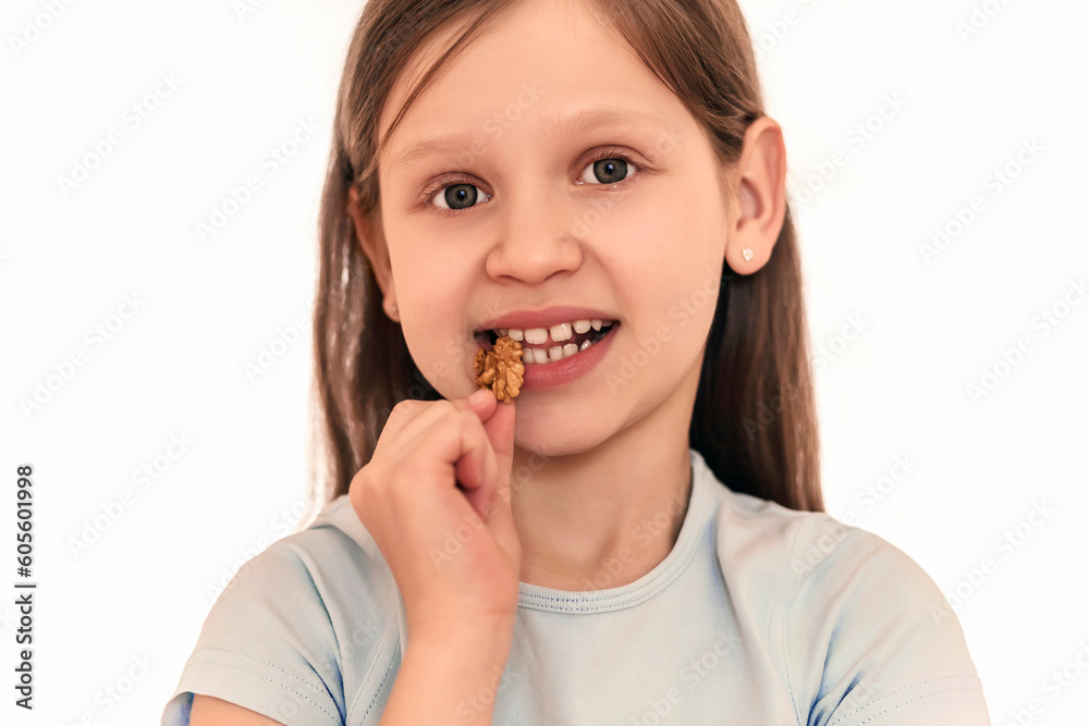 Walnuts for Children. Little Girl Kid Eating Nut Walnut isolated on White Background. Healthy Food for Kids. Walnuts for Children. Little Girl Kid Eating Nut Walnut isolated on White Background. Healthy Food for Kids.