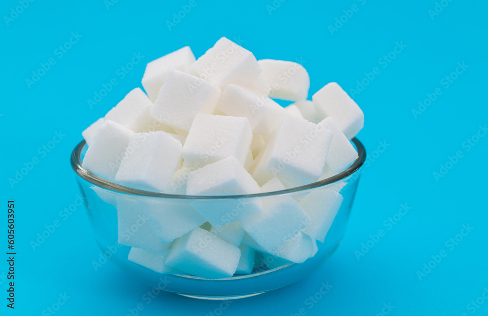 Sugar cubes in a bowl on blue background Sugar cubes in a bowl on blue background