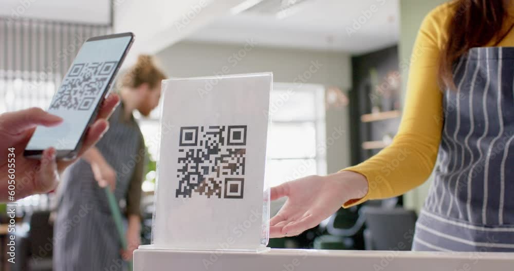 Midsection of caucasian female hairdresser and client using qr code with smartphone, in slow motion