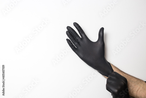 Medical black gloves on a male hand on a white background.