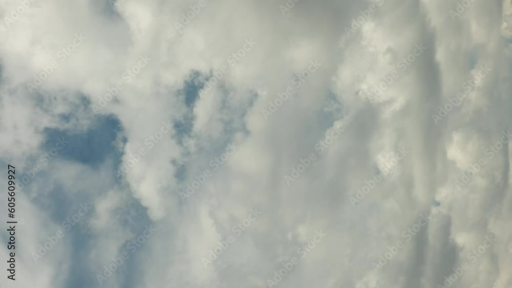 Dramatic time-lapse of moving white clouds in stormy sky. Timelapse of dynamic cloudscape in dramatic sky, vertical video