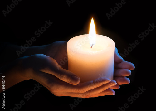 Women's hands holding a candle