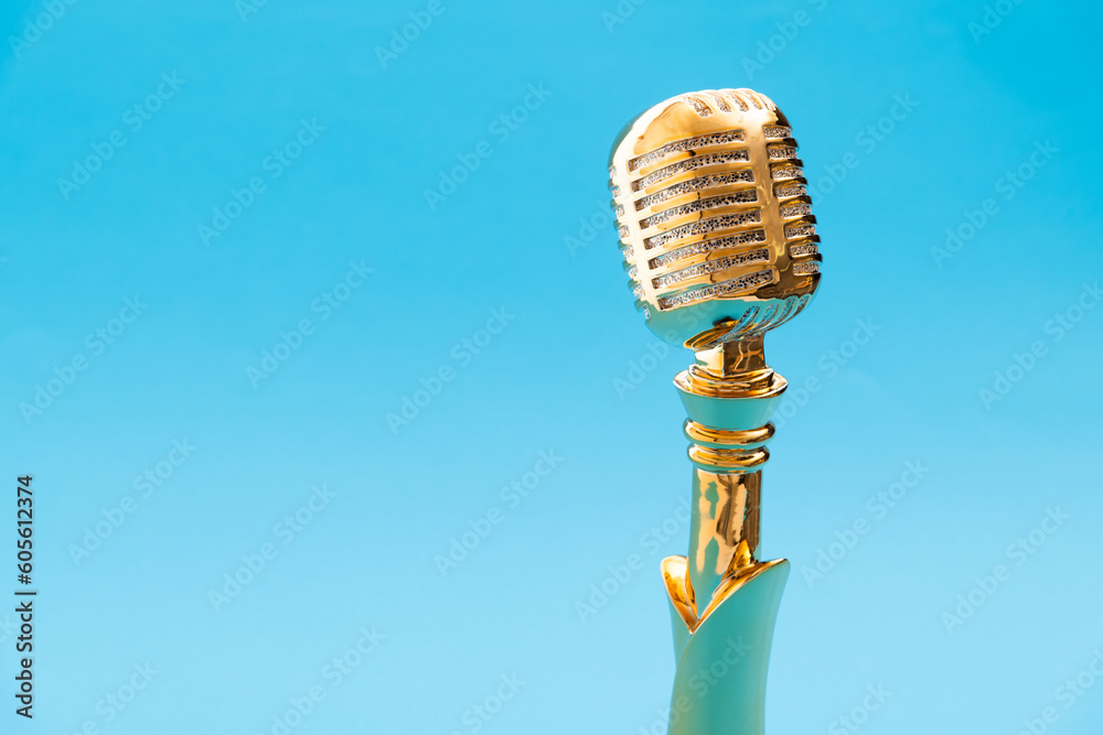 Golden microphone trophy on blue background Stock Photo | Adobe Stock