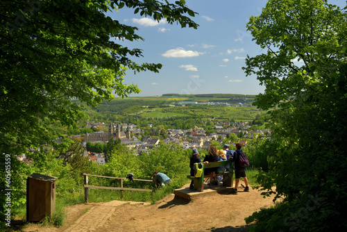 Eine Familie sitzt auf einer Parkbank und genießt die Aussicht auf die Stadt Echternach in Luxemburg.