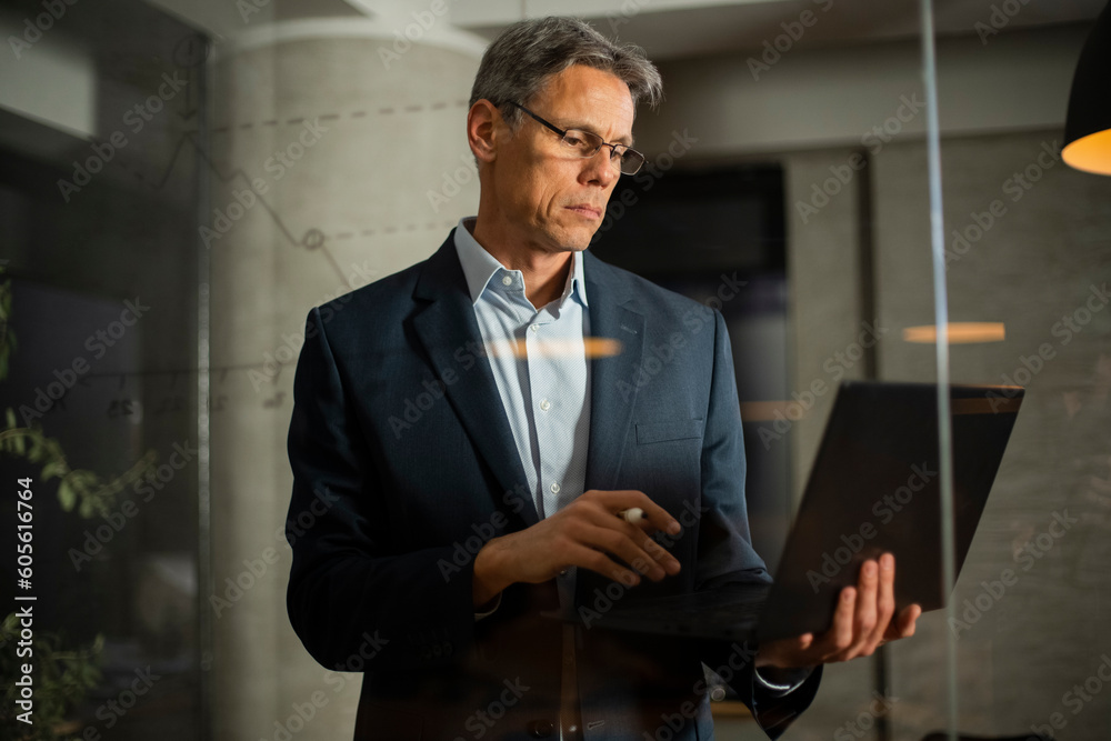 Portrait of successful businessman in office. Man writing on the glass board in office Portrait of successful businessman in office. Man writing on the glass board in office