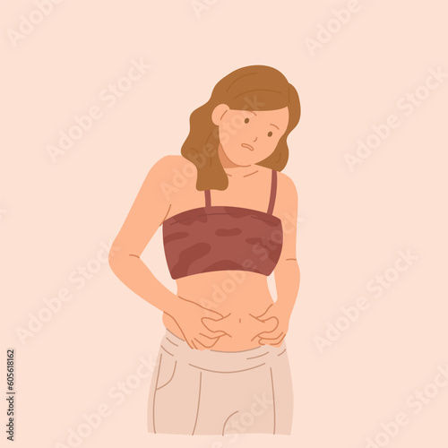Young sad woman grabbing her fat on the stomach.
