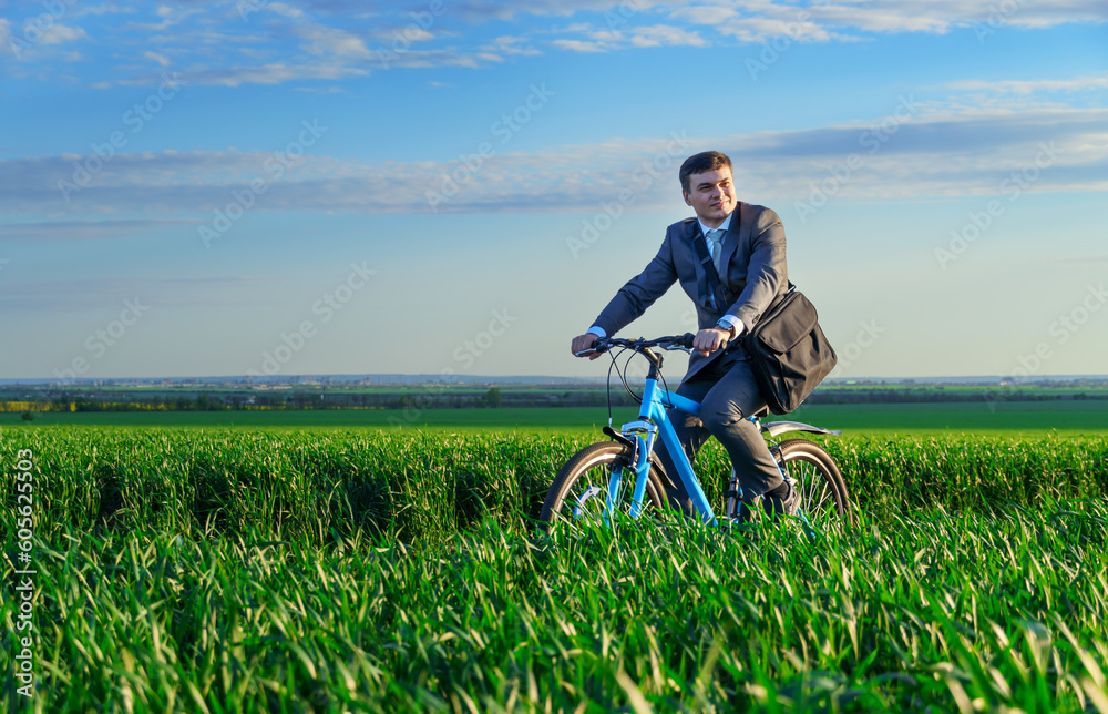 a businessman rides a bicycle on a green grassy field, dressed in a business suit, beautiful nature in spring, freelance business concept a businessman rides a bicycle on a green grassy field, dressed in a business suit, beautiful nature in spring, freelance business concept