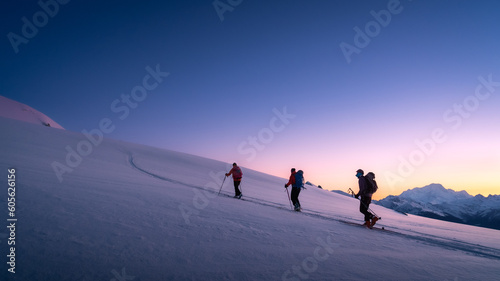 Skiers touring in winter, full of snow, at sunrise under a beautfiul clear sky full of colors. living the dream