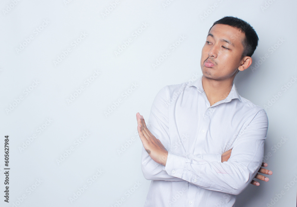 Concerned Indonesian Asian Man showing refusal sign, saying no, raise awarness, standing on the white background with copy space. Concerned Indonesian Asian Man showing refusal sign, saying no, raise awarness, standing on the white background with copy space.