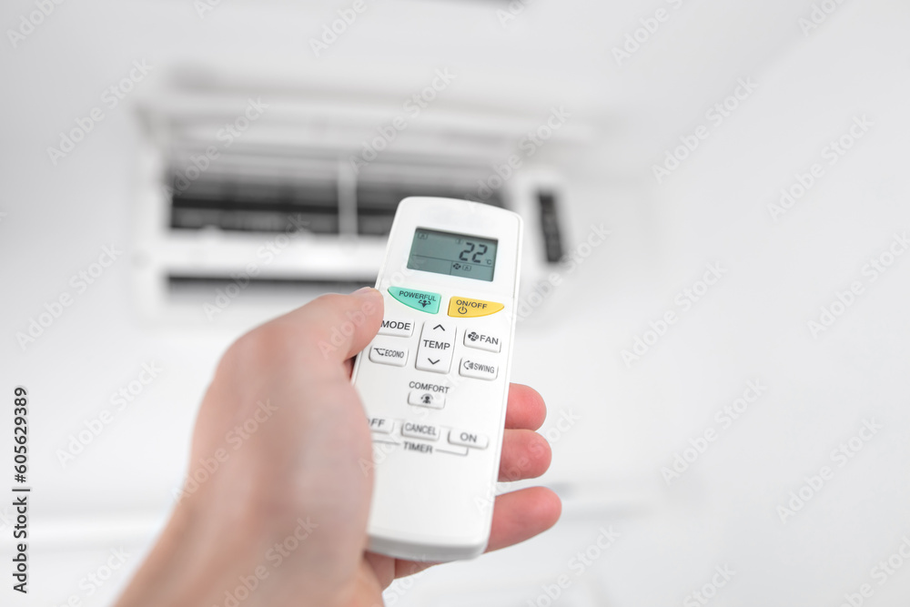 Man holding a modern AC unit remote. Man holding a modern AC unit remote.