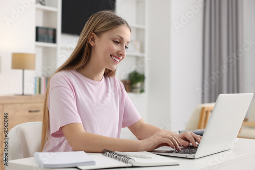 Online learning. Teenage girl typing on laptop at table