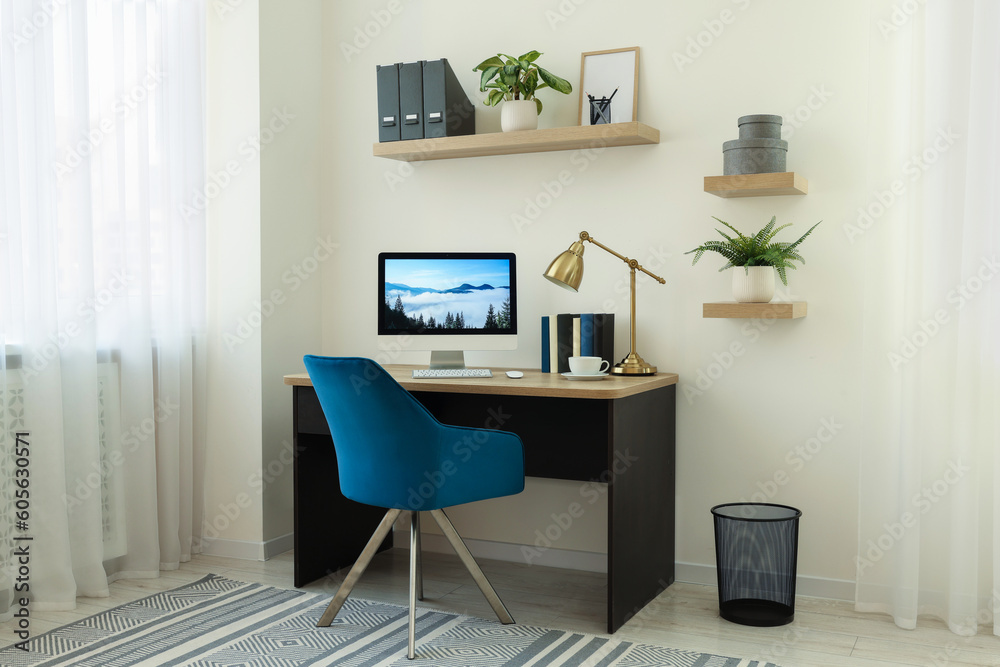 Cozy workspace with computer on wooden desk and comfortable chair at home Cozy workspace with computer on wooden desk and comfortable chair at home