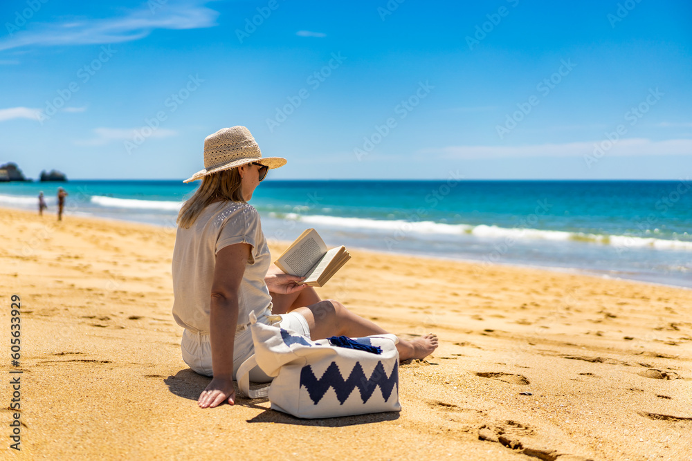 Woman sitting on beach in Alvor, Portugal reading book
Woman sitting on beach in Alvor, Portugal reading book