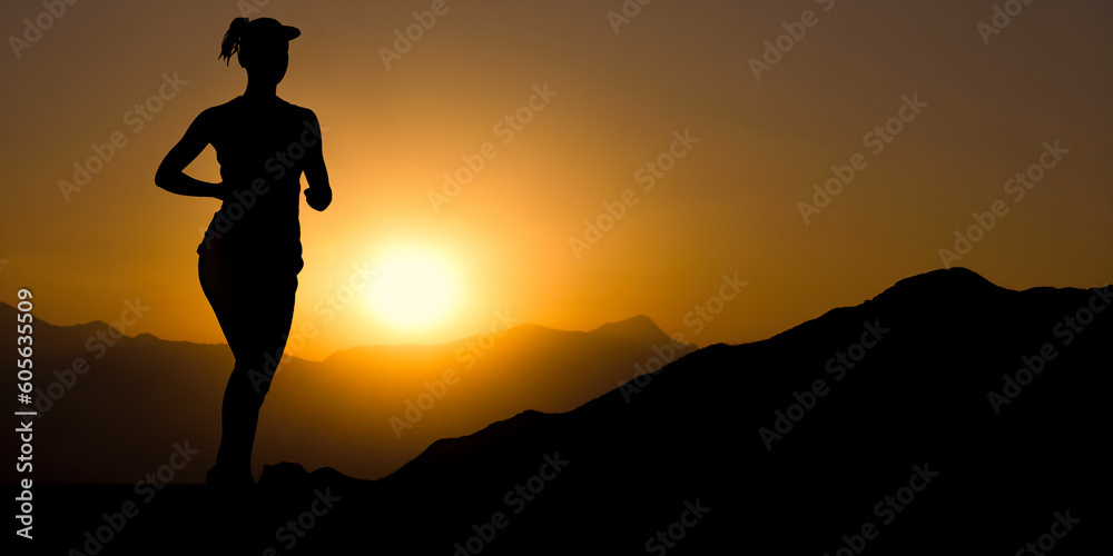 Silhouette of a female runner running at sunset on mountains