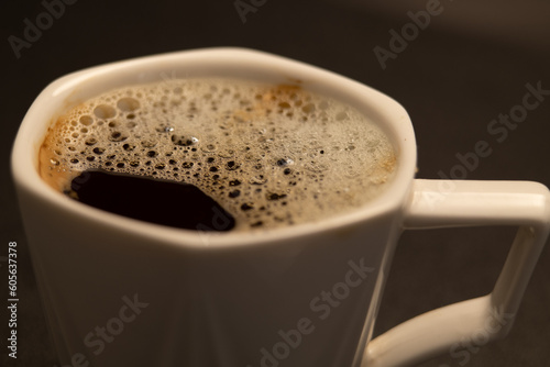 A cup of fresh hot coffee with foam on the surface