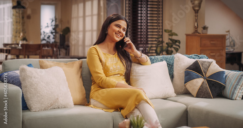 Gorgeous Indian Woman Engaged in a Lively Phone Call at Home: Discussing Work Matters with Colleagues or Clients. Sharing Stories and Laughs with Girlfriends, or Catching Up with Family. Medium Shot