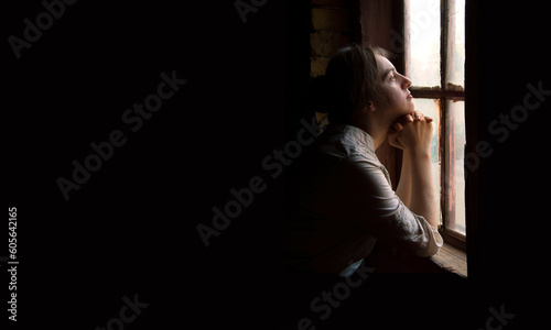 Obraz na plátně Young girl at the old wooden window