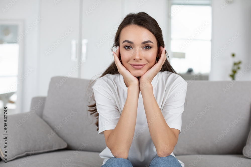 Beautiful positive woman sitting on the couch looking at the camera, online communication. Beautiful positive woman sitting on the couch looking at the camera, online communication.