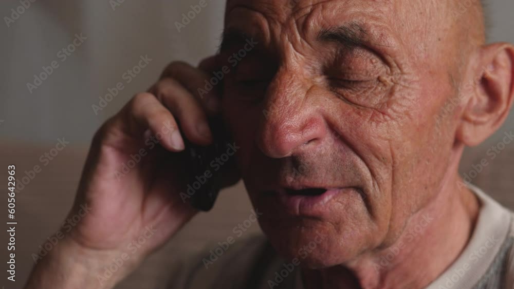 portrait of a caucasian cheerful pensioner talking on the phone while inside. home life of the elderly. lifestyle of pensioners. real people portrait of a caucasian cheerful pensioner talking on the phone while inside. home life of the elderly. lifestyle of pensioners. real people