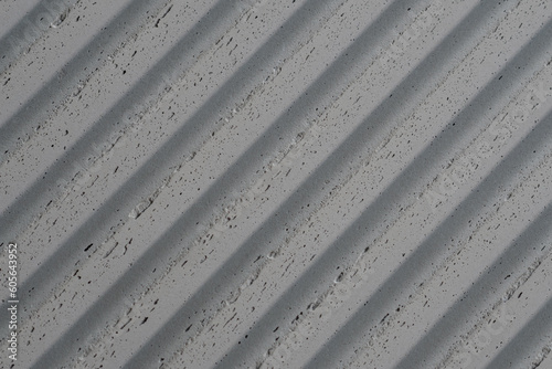 grey concrete wall with deep textured 3d lines vertical, diagonal or horizontal with a lot of copy space for text background